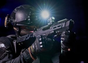 Person in tactical gear aiming a firearm with polymer components
