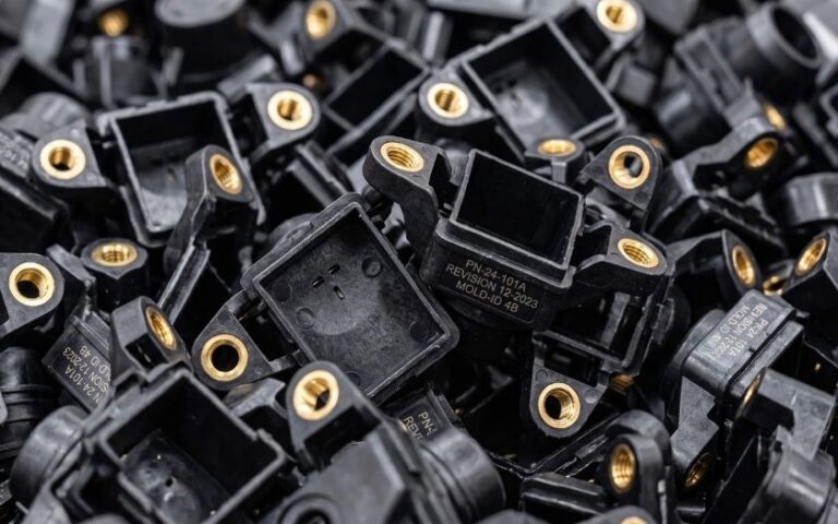 Black insert-molded plastic parts with brass threaded inserts
